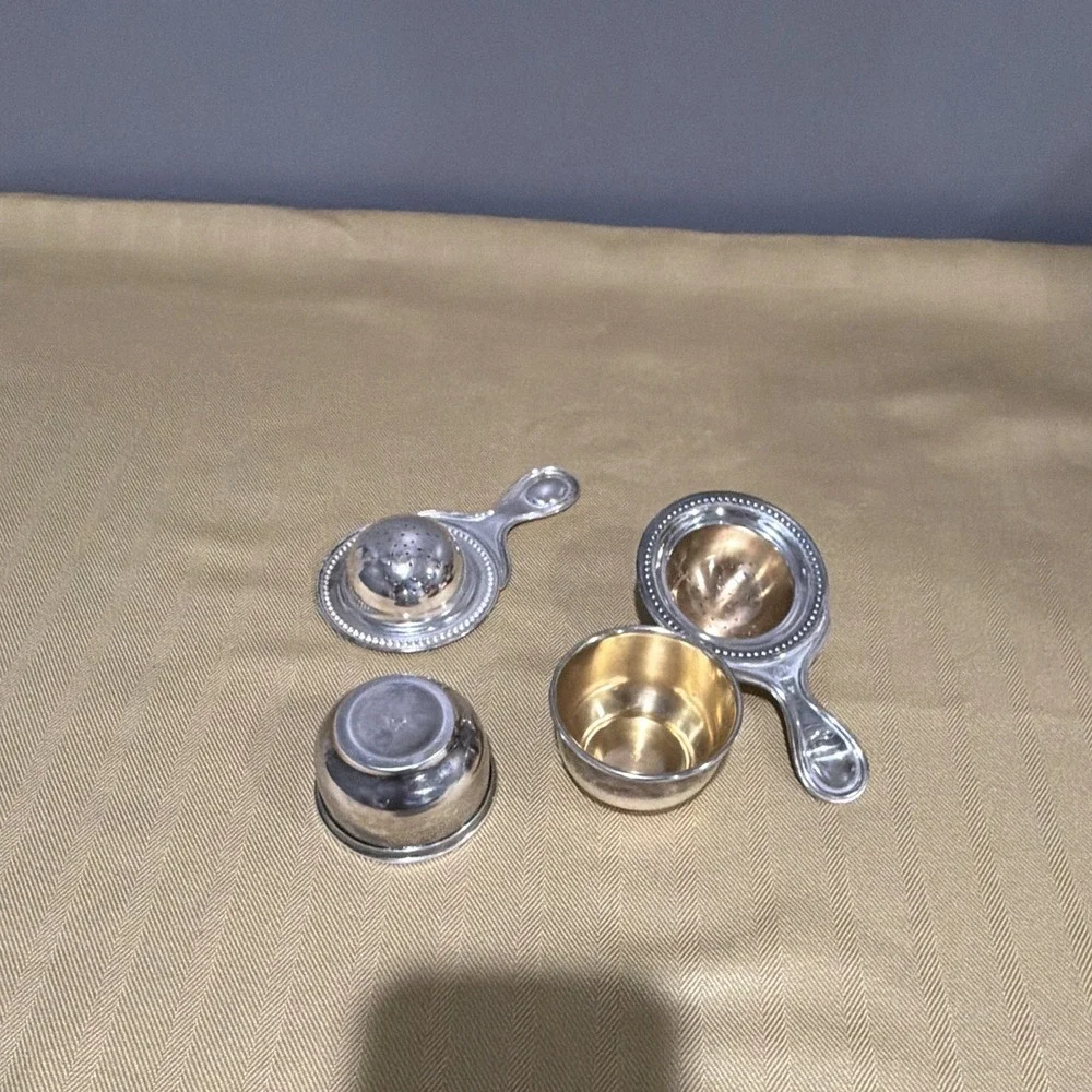 Vintage tea strainers with its matching drip stand.